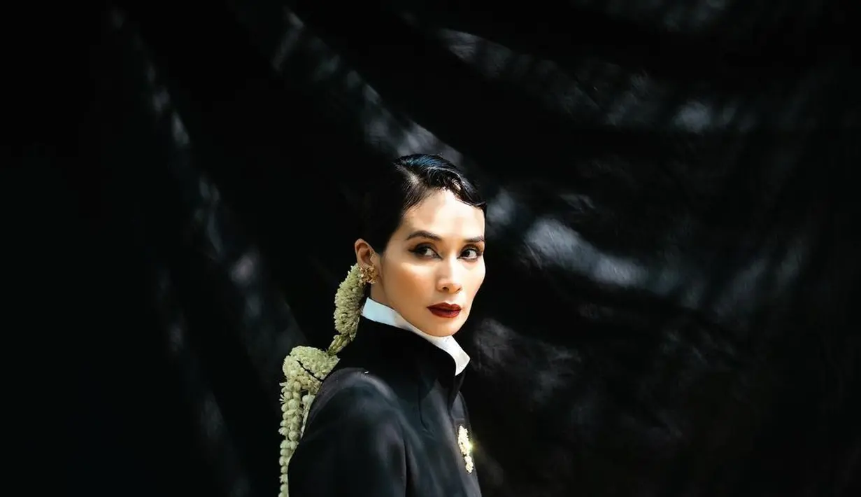 Marsha Timothy mengenakan kebaya Janggan hitam, yang biasanya warna gelap ini digunakan untuk menggambarkan sikap tegas seorang perempuan dan kemampuan mereka dalam memimpin layaknya pria. Marsha Timothy memadukan penampilannya dengan makeup bold dan hiasan bunga melati di rambutnya. [Foto: Instagram/marshatimothy]