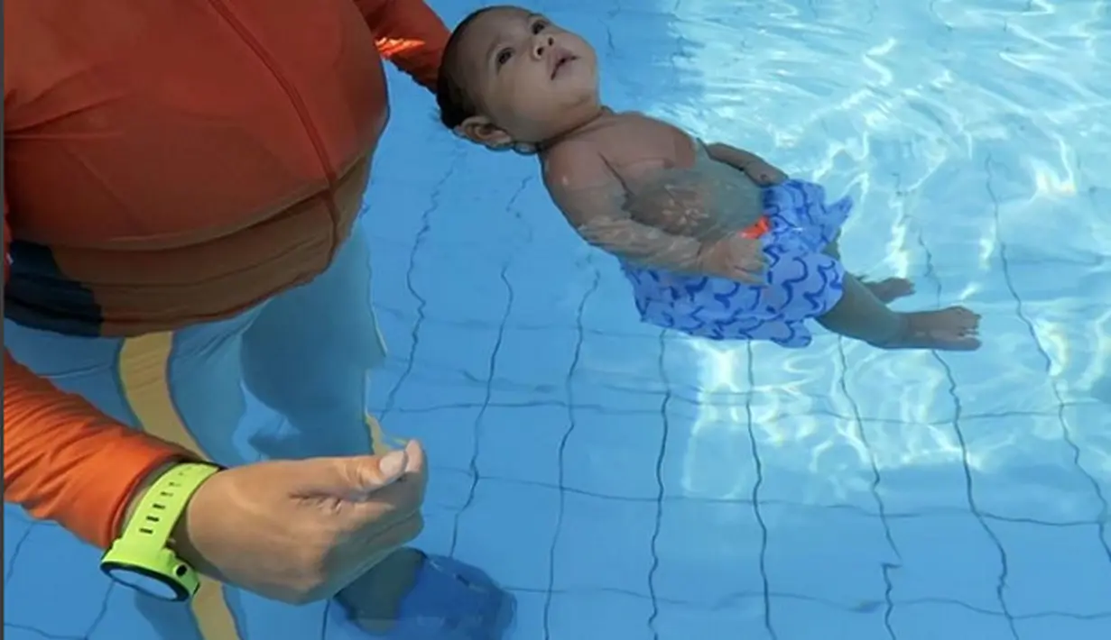 Dengan mengenakan celana pendek, oleh pelatihnya Kawa dibebaskan menggerak-gerakkan tangan serta kedua kakinya. Dari video itu, hanya kepala yang terlihat dipegangi. (Instagram/andienippekawa)