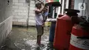 Warga beraktivitas saat banjir rob di Muara Angke, Jakarta, Jumat (25/11/2022). Badan Penanggulangan Bencana Daerah (BPBD) DKI Jakarta mengimbau agar warga di pesisir Jakarta mengantisipasi banjir pesisir atau rob selama 22-28 November 2022. (Liputan6.com/Faizal Fanani)