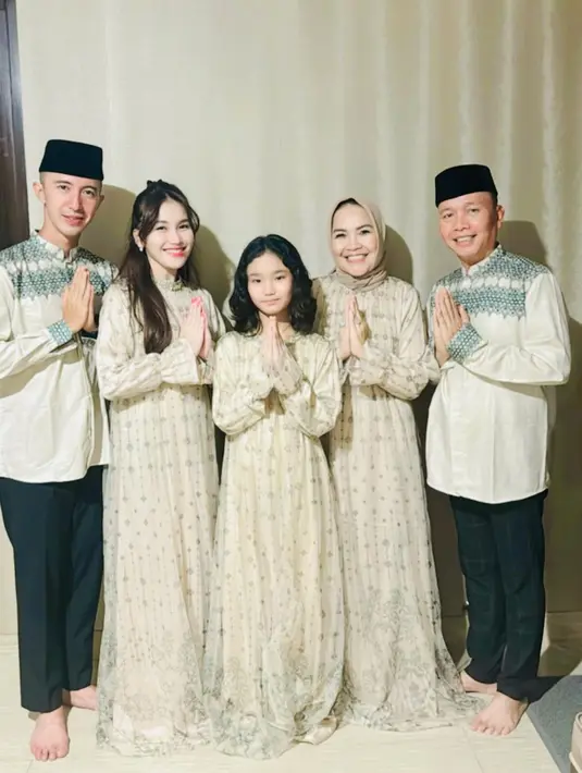 Momen Lebaran Ayu Ting Ting dirayakan dengan tampil kembaran bareng keluarga dan calon suami mengenakan baju sarimbit nuansa krem. Ayu bersama putri dan ibunya kompak pakai dress, sedangkan tunangan Ayu tampil kompak dengan Ayah Ojak pakai baju koko senada. [@mom_ayting92_]