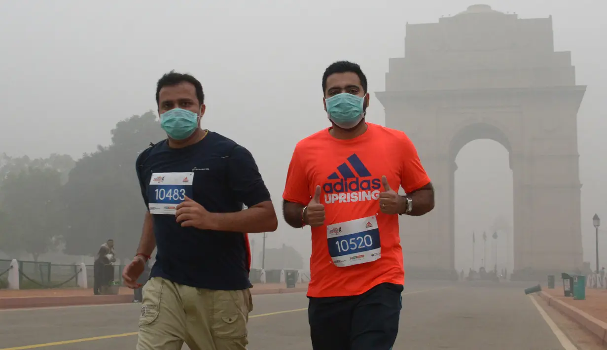 Peserta lari New Delhi 10K menggunakan masker mengikuti lomba ditengah-tengah kabut polusi yang menimpa kota New Delhi, India (6/11). Kabut asap ini diklaim sebagai kabut asap terparah yang dialami oleh New Delhi dalam 17 tahun. (AFP/Dominique Faget)