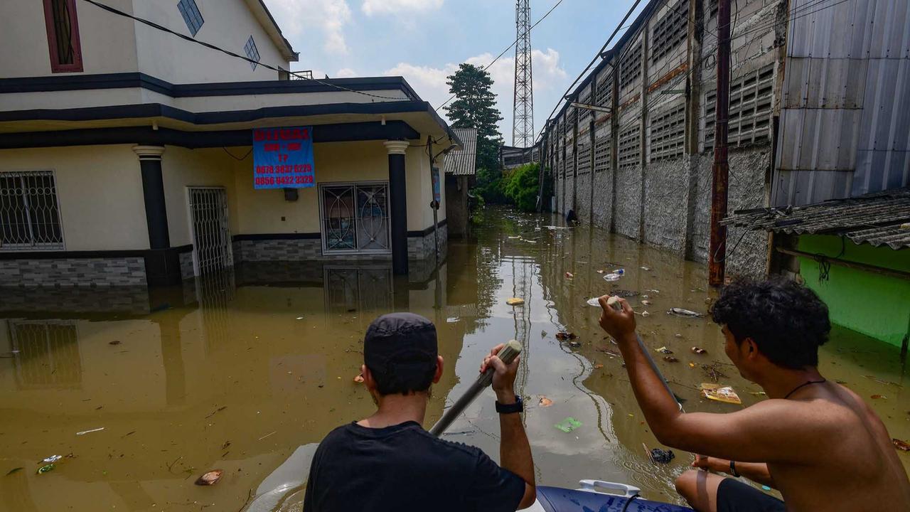 FOTO: Banjir Luapan Kali Angke, Pemuda Tangerang Bahu-Membahu Evakuasi Warga