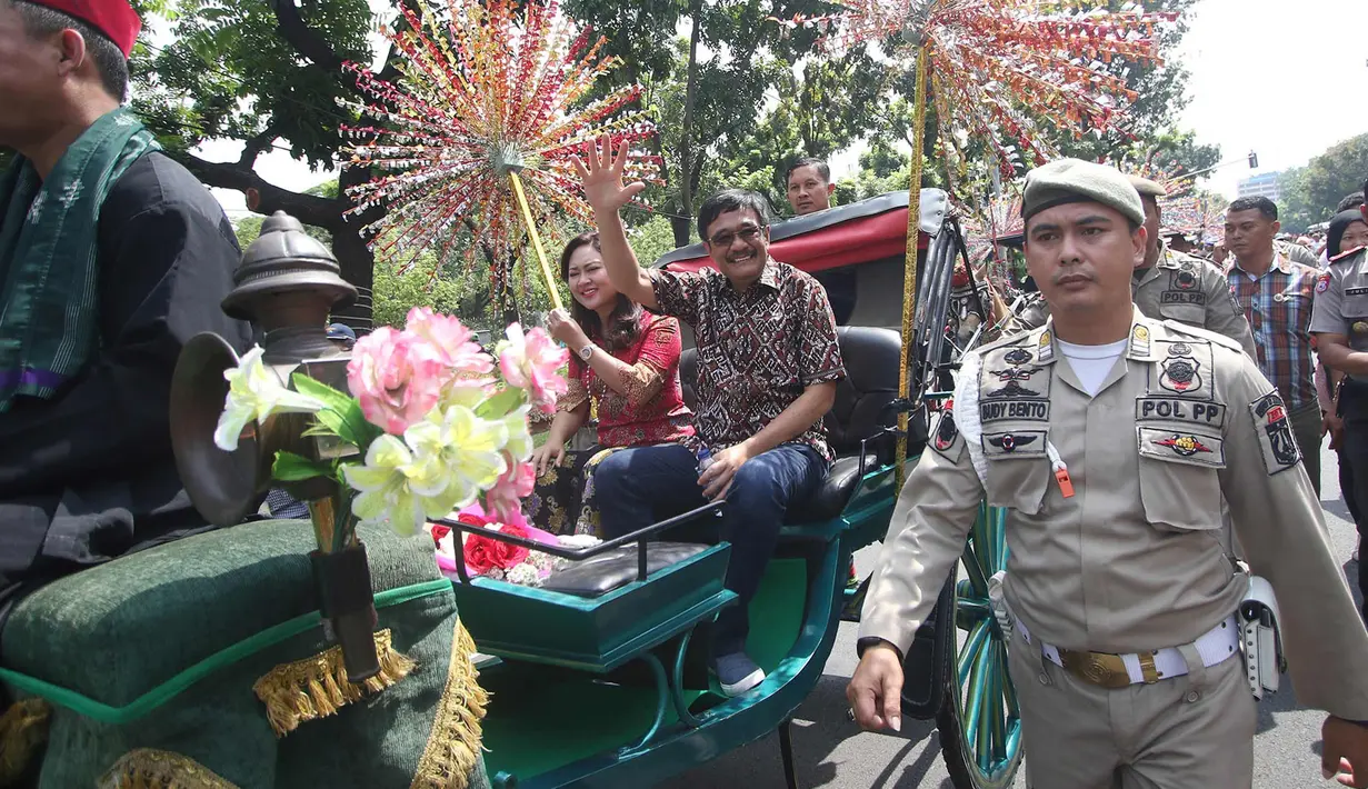 Gubernur DKI Jakarta Djarot Saiful Hidayat bersama istri Happy Farida menaiki delman sambil melambaikan tangan kepada warga dan pegawai Pemprov DKI Jakarta saat perpisahan dirinya di Balaikota DKI Jakarta, Minggu (15/10). (Liputan6.com/Immanuel Antonius)