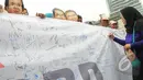 Seorang wanita membubuhkan tandatangannya saat aksi 'Lawan Begal APBD' di Bundaran HI, Jakarta, Minggu (1/3/2015). Aksi mereka sebagai bentuk dukungan kepada Ahok yang ingin membongkar dana siluman di Pemprov DKI (Liputan6.com/Herman Zakharia)