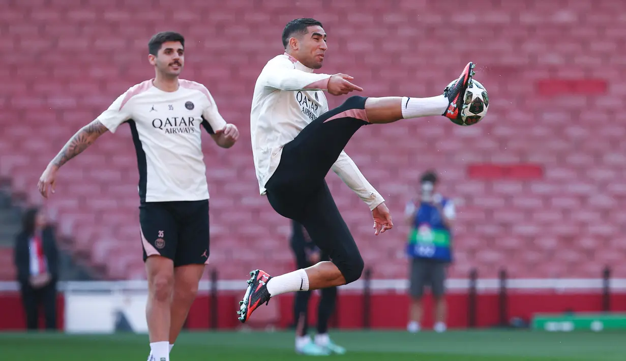Pemain PSG, Achraf Hakimi, mengontrol bola saat sesi latihan jelang laga melawan Arsenal pada laga semifinal Liga Champions. (AFP/Franck Fife)