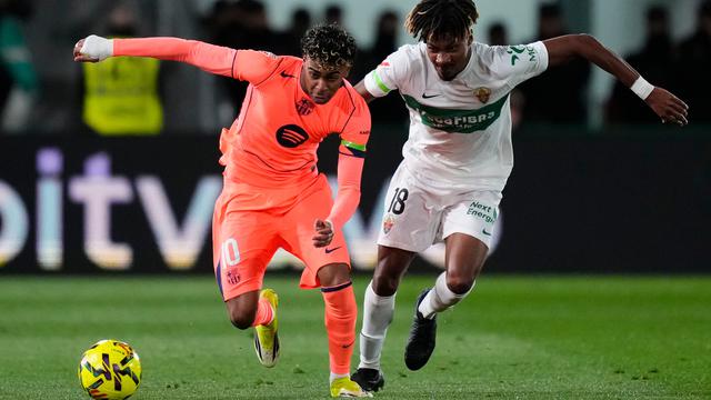 Pemain Barcelona Lamine Yamal (kiri) berebut bola dengan pemain Elche John Donald