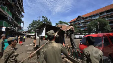 Sejumlah petugas satpol PP membongkar bangunan liar di kawasan rusun tanah tinggi, Jakarta, Rabu (4/3/2015).  Sebanyak 10 bangunan liar di Rumah Susun (Rusun) Tanah Tinggi ditertibkan aparat satpol PP. (Liputan6.com/Faizal Fanani)