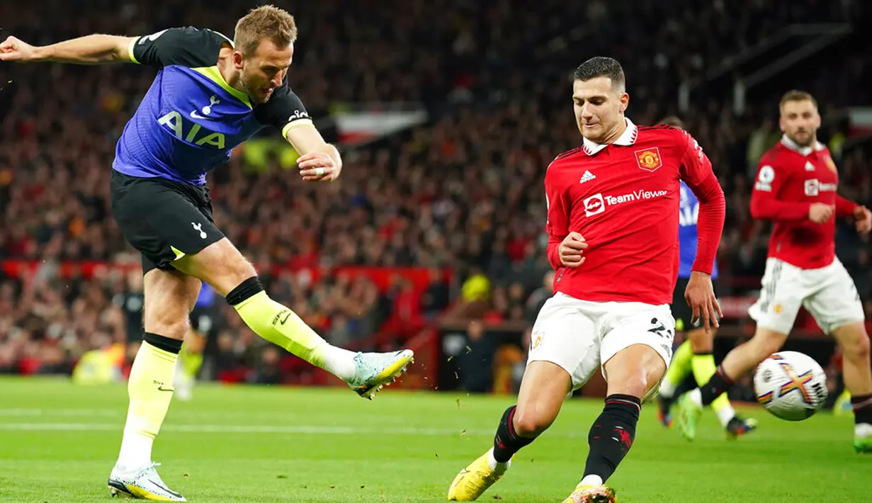 Pemain Tottenham Hotspur Harry Kane (kiri) menendang bola ketika pemain Manchester United Diogo Dalot mencoba untuk memblokir pada pertandingan sepak bola Liga Inggris di Old Trafford, Manchester, Inggris, 19 Oktober 2022. Manchester United mengalahkan Tottenham Hotspur dengan skor 2-0. (AP Photo/Dave Thompson)