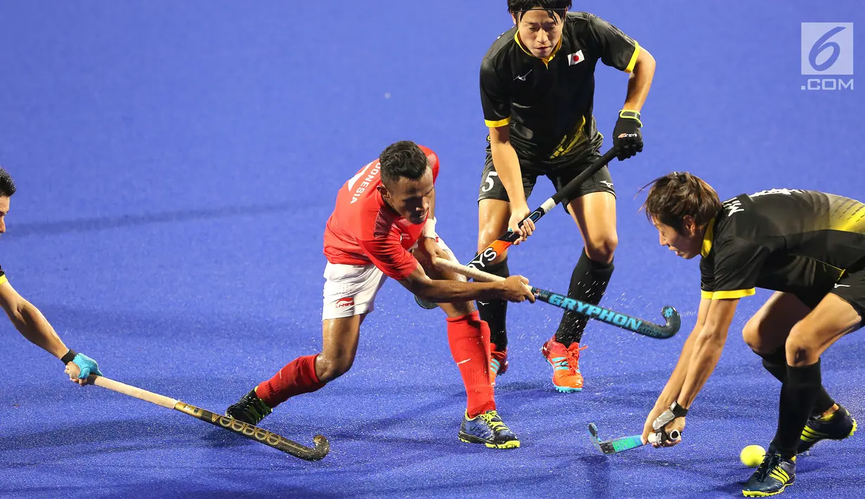 Atlet hoki Indonesia berebut bola saat bertanding melawan Jepang dalam babak penyisihan hoki putra Asian Games di Lapangan Hoki Gelora Bung Karno, Jakarta, Rabu (22/8). Indonesia kalah dengan skor 1-3. (Liputan6.com/Fery Pradolo)