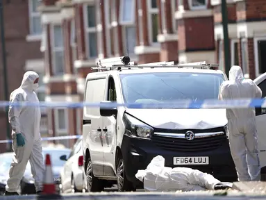 Petugas forensik polisi menggeledah sebuah van putih di sudut Maples Street dan Bentinck Road, Nottingham, Inggris, Selasa (13/6/2023). Tiga orang ditemukan tewas di kota tersebut dalam apa yang digambarkan oleh polisi sebagai 'insiden mengerikan dan tragis'. (Zac Goodwin/PA via AP)