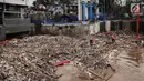 Sebuah eskavator dibantu petugas kebersihan mengangkat tumpukan sampah di Pintu Air Manggarai, Jakarta, Senin (12/11). Sejumlah petugas mengenakan pelampung oranye di atas tumpukan sampah yang berada di sungai. (Liputan6.com/Fery Pradolo)