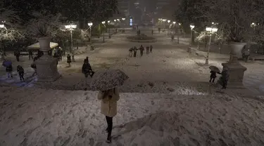Orang-orang saling melempar bola salju di taman yang tertutup salju di Istanbul, Turki, Senin (24/1/2022). Badai salju yang parah mengganggu lalu lintas jalan dan udara pada Senin di ibu kota Yunani, Athena dan di kota tetangga terbesar di Turki, Istanbul. (AP Photo/Emrah Gurel)