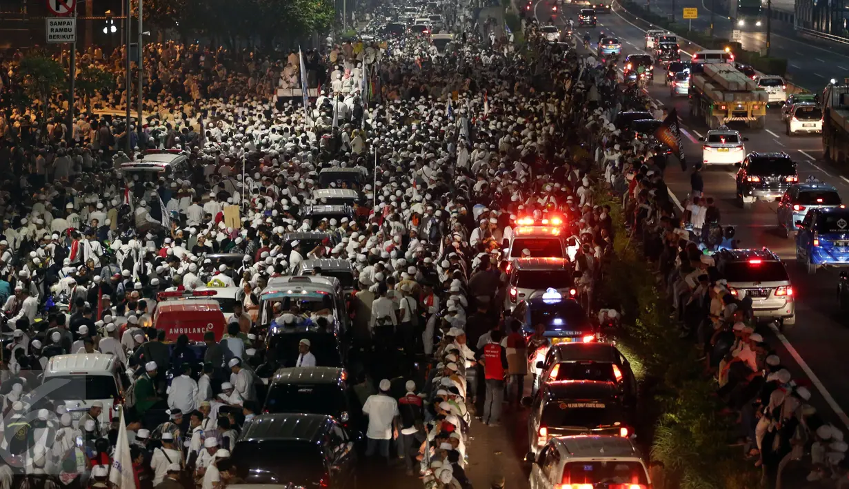 Massa peserta demo 4 November dan kendaraan memadati Jalan Gatot Subroto, Jakarta atau tepat di depan Gedung MPR/DPR RI, Jumat (4/11). Mereka menginap di jalan depan Gedung DPR lantaran tak diizinkan masuk ke komplek parlemen (Liputan6.com/Johan Tallo)