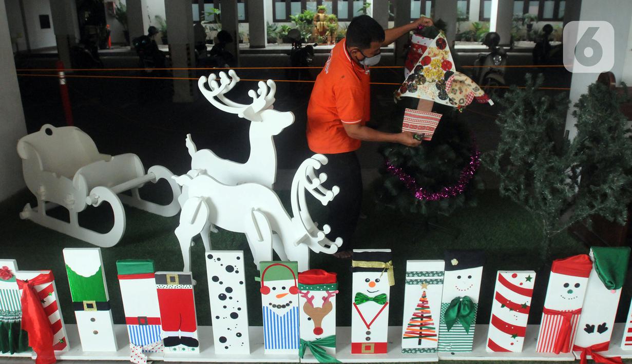 Umat Katolik menghias pohon Natal di Gereja Santo Barnabas, Tangerang Selatan, Banten, Kamis (23/12/2021). Sejumlah gereja di Indonesia mulai melakukan persiapan dan pemasangan dekorasi untuk menyambut misa dan perayaan Natal 2021. (merdeka.com/Arie Basuki)