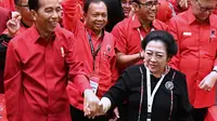 Presiden Joko Widodo atau Jokowi bergandengan tangan dengan Ketua Umum PDIP Megawati Soekarnoputri saat Rakernas PDIP III Tahun 2018 di Badung, Bali, Jumat (23/2). (Liputan6.com/Pool/Biro Pers Setpress)