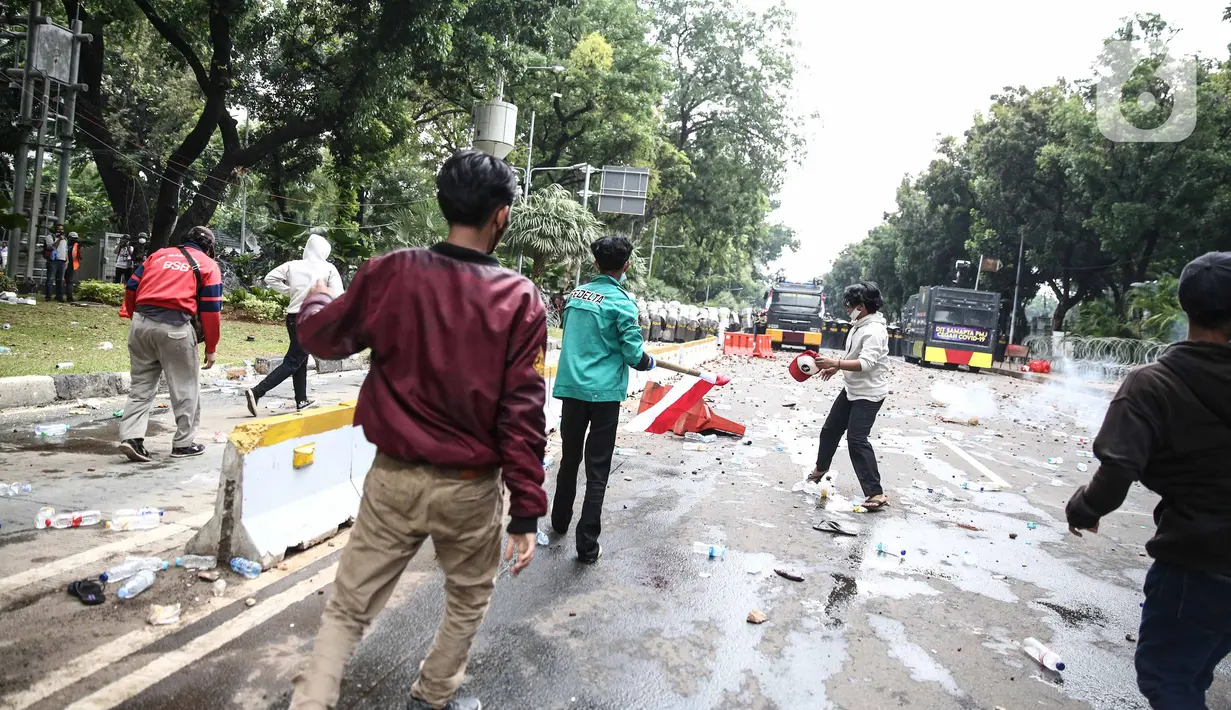 Bentrokan antara pengunjuk rasa tolak UU Cipta Kerja dan aparat kepolisian pecah di kawasan Patung Kuda, Jakarta Pusat, Selasa (13/10/2020). Massa berupaya menerobos barikade polisi yang menutup akses mengarah ke Istana Kepresidenan. (Liputan6.com/Faizal Fanani)