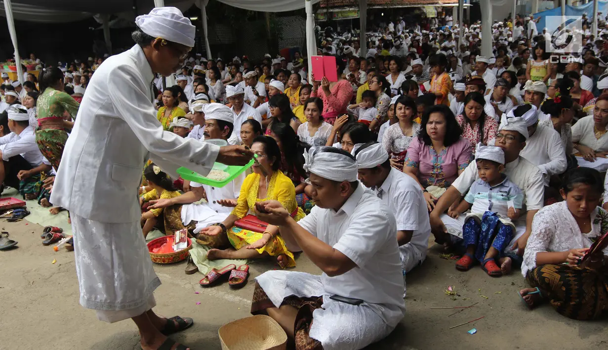 Pemuka agama Hindu memberikan air suci saat upacara Tawur Kesanga di Pura Aditya Jaya, Rawamangun, Jakarta, Jumat (16/3). Upacara Tawur Kesanga digelar sebagai rangkaian perayaan Hari Raya Nyepi Tahun Baru Saka 1940. (Liputan6.com/Arya Manggala)