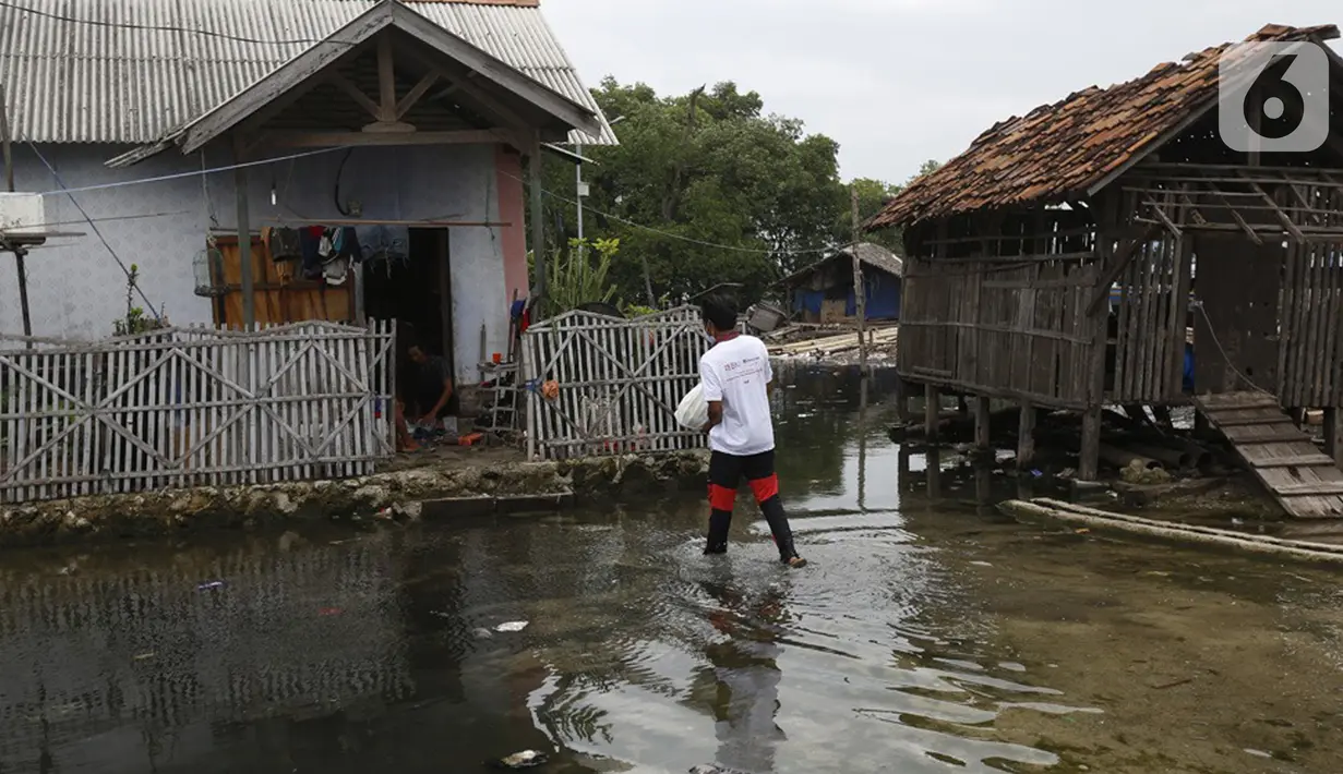 Jurnalis menyalurkan bantuan sembako di Pulau Panjang, Serang, Banten, Sabtu (30/1/2021). Bantuan sembako dan uang tunai bagi warga kurang mampu diberikan karena menurunnya daya beli masyarakat untuk mengonsumsi ikan turun akibat pandemi Covid-19. (Liputan6.com/Pool/JP)