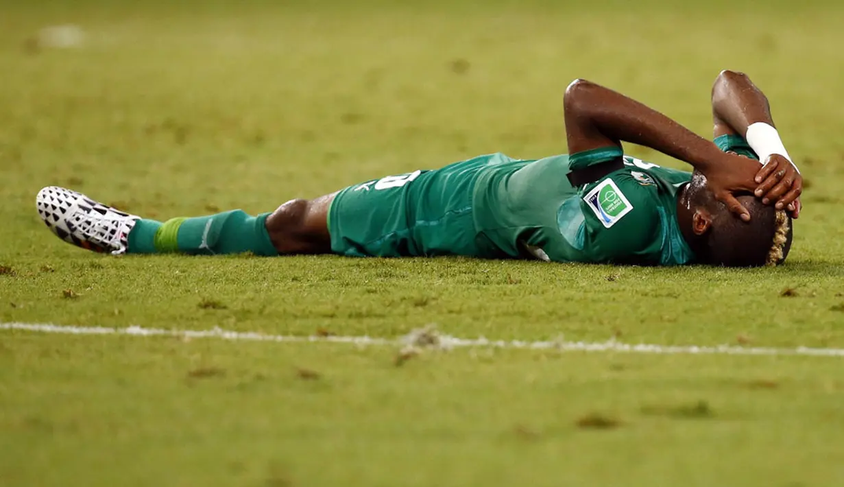 Pemain Pantai Gading, Geoffroy Serey Die, tergeletak di lapangan usai dikalahkan Yunani 1-2 di Stadion Castelao, Fortaleza, Brasil, (25/6/2014). (REUTERS/Mike Blake)