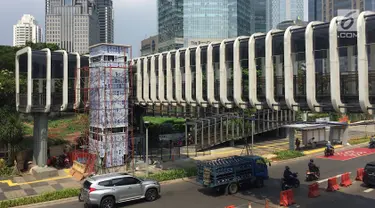 Suasana pembangunan lift pada jembatan penyeberangan orang di kawasan Senayan, Jakarta, Senin (13/5). Pembangunan lift pada tiga JPO yang berada di Jalan Sudirman itu bertujuan meningkatkan kenyamanan kepada warga dan ditargetkan rampung akhir bulan ini. (Liputan6.com/Immanuel Antonius)