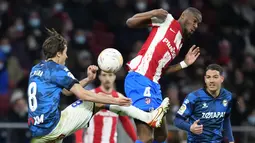 Gelandang Deportivo Alaves Tomas Pina berebut bola dengan gelandang Atletico Madrid Geoffrey Kondogbia dalam lanjutan La Liga Spanyol, Minggu (3/4/2022) dinihari WIB. Atletico Madrid menang telak dengan skor 4-1 atas Deportivo. (AP Photo/Manu Fernandez)