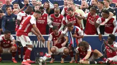 Striker Arsenal, Pierre-Emerick Aubameyang menjatuhkan trofi saat perayaan gelar juara Piala FA usai mengalahkan Chelsea pada pertandingan final Piala FA di stadion Wembley, Minggu (2/8/2020).  Aubameyang terlihat kaget sambil memegang kepalanya saat trofi terjatuh. (Catherine Ivill/Pool via AP)