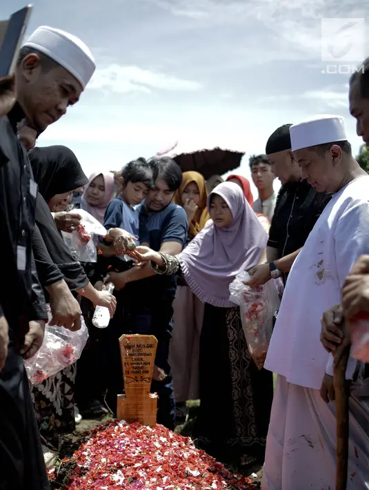 Penyanyi religi Opick dan keluarga usai memakamkan almarhum istri keduanya Wulan Mayasari di TPU Semper, Jakarta, Senin (19/3). Diiringi shalawat nabi dan tahlil, Opick memakamkan istrinya dengan wajah yang tegar. (Liputan6.com/Faizal Fanani)