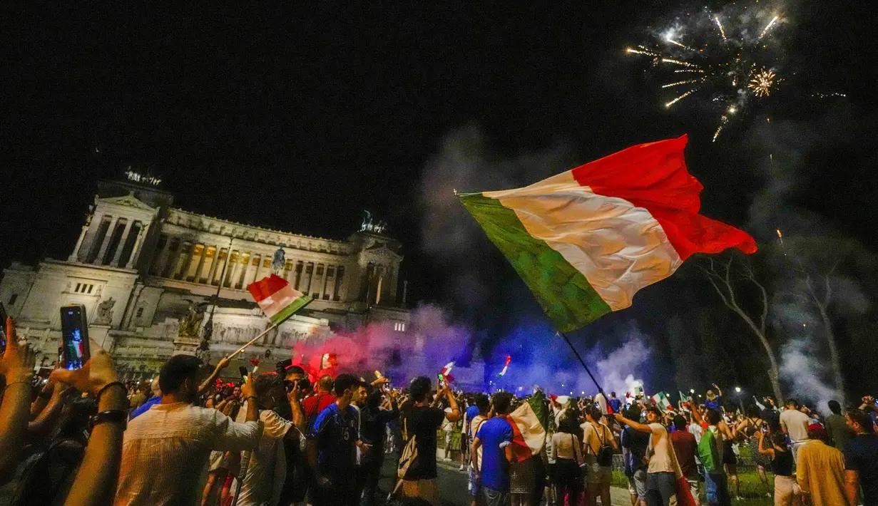 Suporter merayakan kemenangan Italia atas Inggris pada pertandingan final Euro 2020 di Roma, Italia, Senin (12/7/2021). Italia menjuarai Euro 2020 usai mengalahkan Inggris lewat drama adu penalti pada pertandingan final. (AP Photo/Alessandra Tarantino)