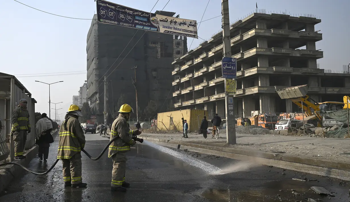 Petugas pemadam kebakaran membersihkan lokasi ledakan bom di Kabul (2/2/2021).  Dua orang tewas ketika ibu kota Afghanistan diguncang serangkaian bom mobil pada jam sibuk, kata para pejabat, sementara seorang polisi kendaraan menjadi sasaran dalam serangan di utara Kabul. (AFP/Bangun Kohsar)
