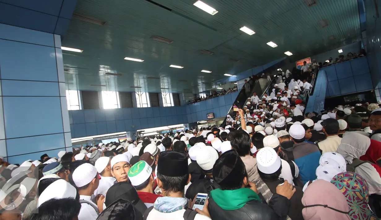 Sejumlah peserta Aksi Damai 112 antre masuk ke dalam Stasiun Juanda, Jakarta, Sabtu (11/2). Banyaknya massa yang ikut dalam Aksi Damai 112 membuat penumpang KRL membeludak dan memenuhi Stasiun Juanda. (Liputan6.com/Immanuel Antonius)