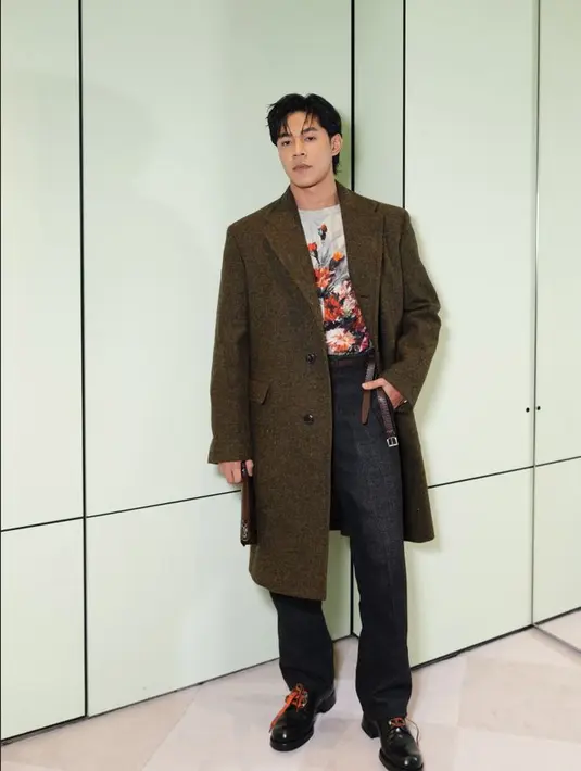 Meerqeen tampak mencuri perhatian dengan single-breasted wool coat dengan printed top. Dipadukan dengan antiqued leather lace-up shoes yang selaras untuk tampilan ini. / Foto dok: Prada.