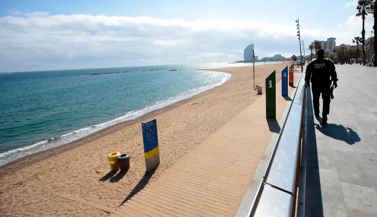 Polisi berpatroli mencegah akses ke pantai di Barcelona, Spanyol, Minggu (15/3/2020). Lockdown mengantisipasi penyebaran virus corona COVID-19 di Spanyol juga membuat tempat rekreasi dan hiburan ditutup. (AP Photo/Joan Mateu)