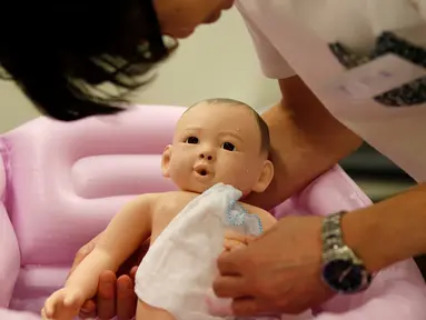 Sejumlah pria mengikuti "Ikumen", kursus mengasuh bayi yang diselenggarakan oleh sebuah perusahaan yang berbasis di Osaka, Tokyo, Jepang (18/9). Kursus ini untuk memberikan pengajaran cara mengasuh bayi yang benar kepada kaum pria. (REUTERS/Issei Kato)
