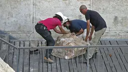 Pekerja Otoritas Pengurus Benda Antik Israel berusaha memindahkan batu besar yang jatuh dari Tembok Ratapan di Kota Tua Yerusalem, Rabu (25/7). Insiden ini terjadi di area yang tergolong tidak terlalu banyak dikunjungi peziarah Yahudi (AFP/AHMAD GHARABLI)