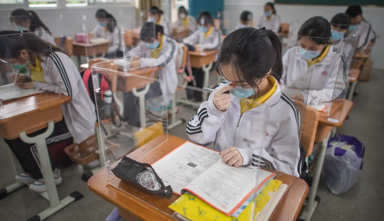 Siswa belajar dengan pemisah pada masing-masing meja mereka sebagai langkah pencegahan penyebaran COVID-19 di Sekolah Menengah No. 23 Wuhan, Wuhan, Provinsi Hubei, China, Rabu (6/5/2020). Sekitar 57.800 siswa tingkat akhir dari 121 SMA dan kejuruan di Wuhan kembali bersekolah. (Xinhua/Xiao Yijiu)
