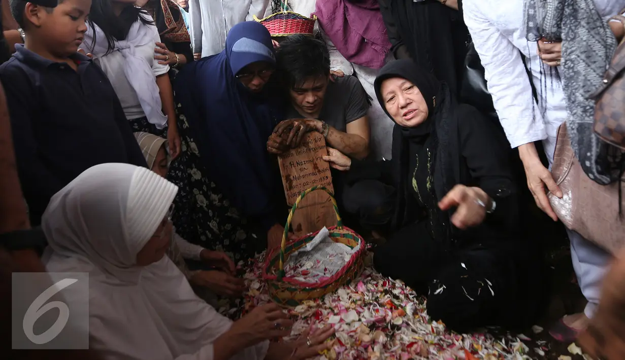 Keluarga dan kerabat menaburkan bunga di atas pusara almarhum ayah Ariel NOAH, Nazmul Irphan bin Muhammad Saleh, Bandung, Selasa (29/3/2016). Almarhum dimakamkan di TPU Nagrog di kawasan Ujung Berung (Liputan6.com/Herman Zakharia)