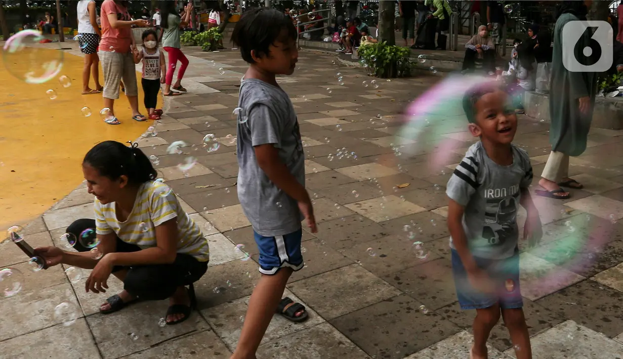 Anak-anak bermain gelembung sabun saat menghabiskan waktu di Taman Puring, Jakarta, Minggu (9/1/2022). Di tengah ancaman penyebaran covid-19 varian Omicron dan pemberlakukan PPKM level 2, masyarakat tetap melakukan aktivitas pada akhir pekan di luar rumah. (Liputan6.com/Johan Tallo)