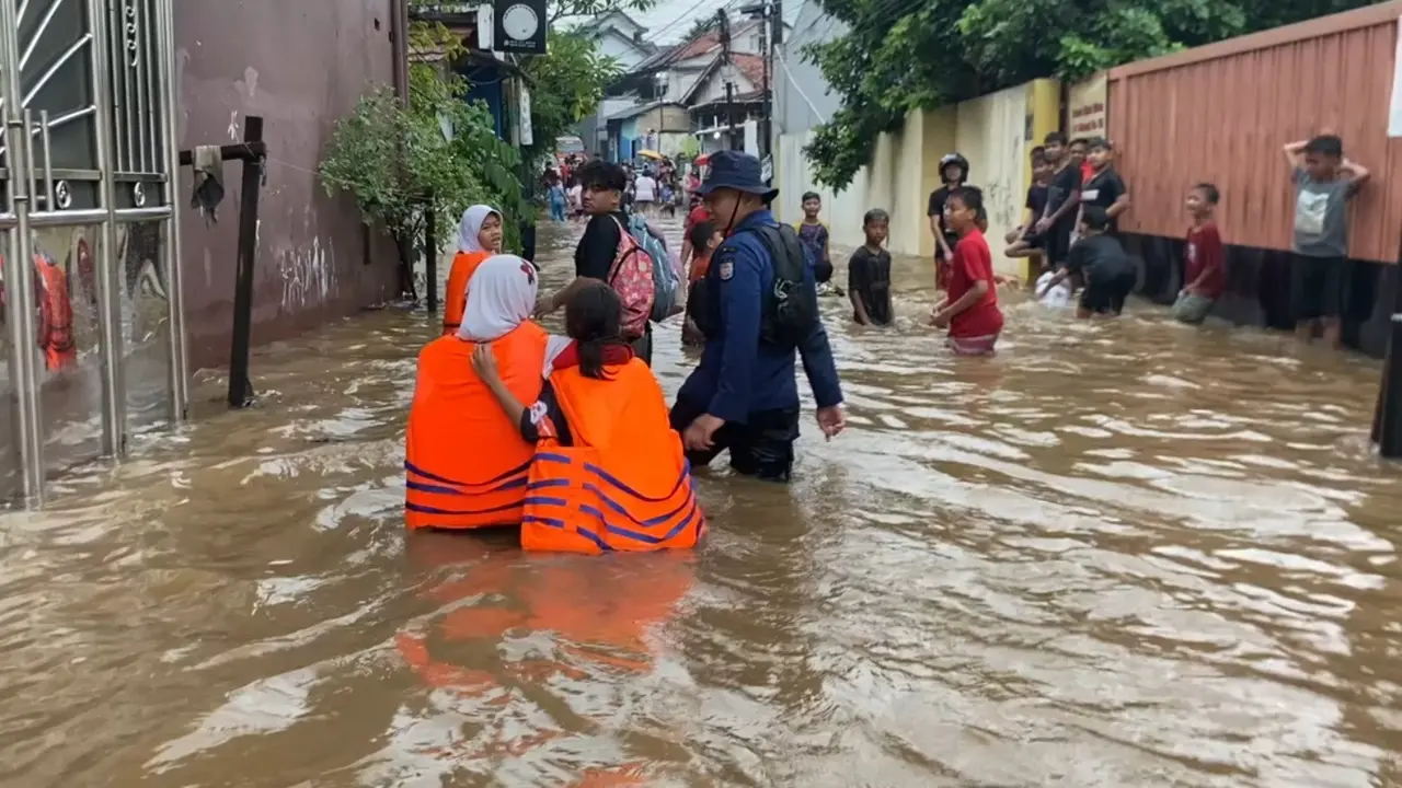Petugas DPKP Kota Depok membantu mengarahkan siswa terjebak banjir usai pulang sekolah di wilayah Pancoran Mas, Depok. (Istimewa)