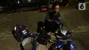 Seorang pria merapikan kostum robot kawasan Tomang, Jakarta, Selasa (14/9/2021). Abi (20) dan Nujum (48) mengenakan kostum robot Iron Man untuk mengais rejeki dan menghibur para pengendara dari kemacetan lalu lintas yang dilakukan sejak pandemi COVID-19. (merdeka.com/Imam Buhori)