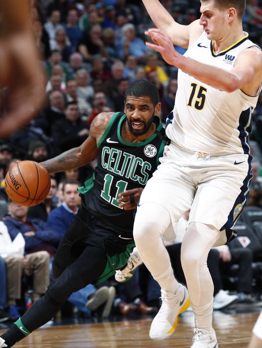 Pemain Boston Celtics, Kyrie Irving (kiri) berusaha melewati adangan pemain Denver Nuggets, Nikola Jokic pada laga NBA basketball game di Pepsi Center, Denver, (29/1/2018). Celtics menang 111-110. (AP/David Zalubowski)