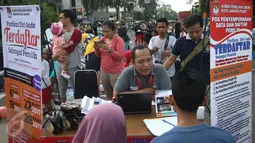 Petugas KPUD DKI Jakarta mendata warga yang mendaftarkan diri di Pos Penyempurnaan Data dan Daftar Pemilih saat pelaksanaan HBKB di Jakarta, Minggu (12/3). (Liputan6.com/Immanuel Antonius)