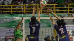 Pevoli Jawa Barat, Amalia Fajrina, dan Putri Andya, menahan bola pevoli Jawa Timur, Megawati Hangestri. Pada set pertama Jabar menang 25-16 atas Jatim. (Bola.com/Vitalis Yogi Trisna)