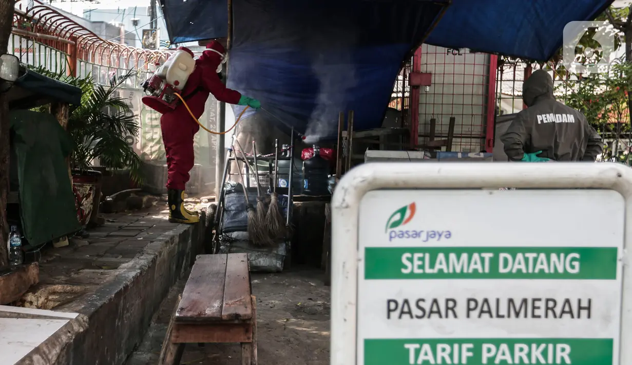 Petugas menyemprotkan Cairan Disinfektan di Pasar Palmerah, Jakarta, Kamis (25/6/2020). Pada hari ini pasar pelmerah resmi ditutup selama 3 hari kedepan dikarenakan 9 pedagang dinyatakan positif Covid-19. (Liputan6.com/Johan Tallo)