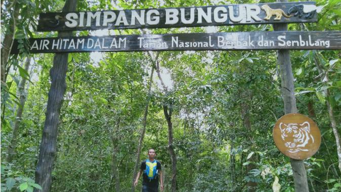 Seorang wisatawan saat berjalan di keluar dari pintu gerbang kawasan ecowisata Taman Nasional Berbak dan Sembilang (TNBS) di Simpang Bungur, Resort I, Kabupaten Tanjung Jabung Timur, Jambi, Sabtu (27/7/2019). (Liputan6.com/Gresi Plasmanto)