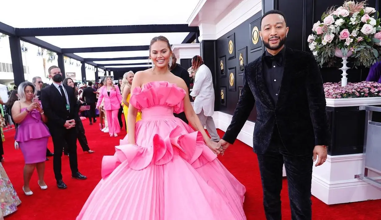 Chrissy Teigen juga masuk dalam jajaran best-dressed Grammy 2022 dalam balutan gaun bervolume merah muda dari Nicole + Felicia Couture(Foto: Instagram @recordingacademy)