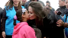 Utusan khusus lembaga pengungsi PBB, aktris Angelina Jolie mendapat ciuman seorang anak Suriah saat berkunjung ke Kamp Pengungsi Zaatari di Mafraq, Yordania, Minggu (28/1). Jolie mengaku prihatin dengan kondisi pengungsi Suriah. (AP Photo/Raad Adayleh)