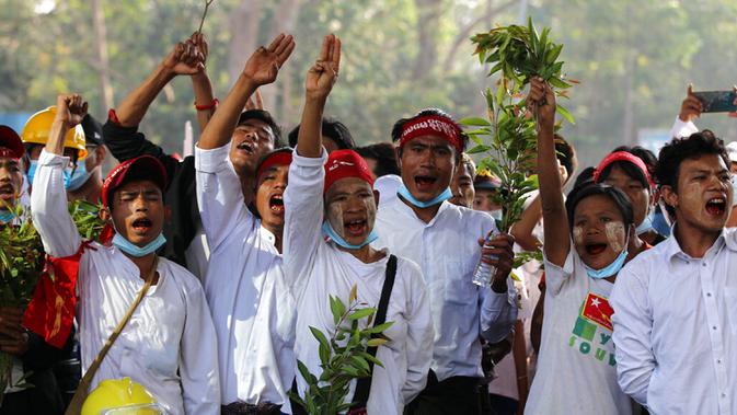 Pengunjuk rasa antikudeta memberikan penghormatan tiga jari di luar Hledan Center, Yangon, Myanmar, Senin (22/2/2021). Pernyataan militer Myanmar terhadap demonstran muncul usai kematian seorang perempuan yang ikut berdemo. (AP Photo)