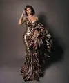 Rapper berbakat ini tampil memukau dalam gaun emas karya Roberto Cavalli yang menonjolkan siluet mermaid dengan korset yang mempertegas lekuk tubuhnya. [@iamcardib].