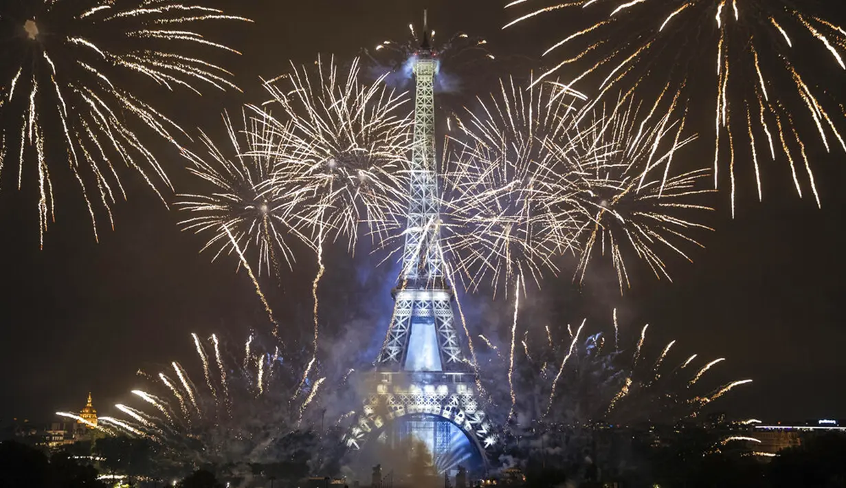 Kembang api menerangi Menara Eiffel pada perayaan Hari Bastille di Paris, Prancis, Rabu (14/7/2021). Prancis telah merayakan hari libur nasionalnya dengan ribuan tentara berbaris dalam parade Paris dan pesta tradisional di seluruh negeri. (AP Photo/Lewis Joly)