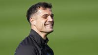 Pemain Bayer Leverkusen, Granit Xhaka, tersenyum saat sesi latihan jelang laga melawan AC Milan pada laga Liga Champions. (AP Photo/Martin Meissner)
